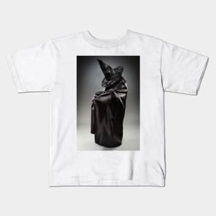 Witch wearing black attire with face hidden Kids T-Shirt